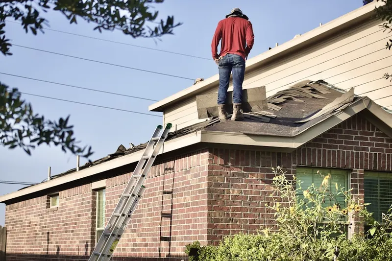 Professional roofer working on a residential roof in Hamilton Lakes